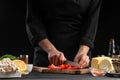 The chef cuts cherry tomatoes to prepare a tasty and fresh salad. Vegetarian and fresh food, gastronomy and cooking, recipe book Royalty Free Stock Photo