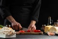 The chef cuts cherry tomatoes to prepare a tasty and fresh salad. Vegetarian and fresh food, gastronomy and cooking, recipe book Royalty Free Stock Photo