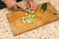 The chef cuts the cucumber on a wooden Board. Royalty Free Stock Photo