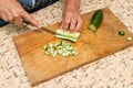 The chef cuts the cucumber on a wooden Board. Royalty Free Stock Photo