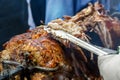 Chef cuts the finished lamb into pieces on a spit over hot coals Royalty Free Stock Photo
