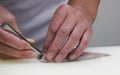 Chef cuts the fish into pieces of sushi