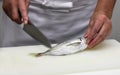 Chef cuts the fish into pieces of sushi (1)