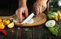 The chef cuts the onion with a knife on the cutting board of the kitchen for cooking pickled vegetables in a jar. Close-up of cook Royalty Free Stock Photo