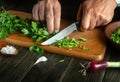 Chef cuts parsley on a cutting board with a knife. Cooking vegetarian food at home. The idea of a vegetable diet Royalty Free Stock Photo