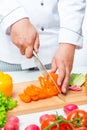 Chef cuts the peppers into thin slices on a wooden board Royalty Free Stock Photo