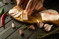 The chef cuts pork lard with a knife on a wooden cutting board. Concept of delicious peasant food lard with garlic Royalty Free Stock Photo