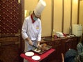 A chef is cutting beijing duck