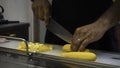 Chef cutting with a big knife yellow zucchini
