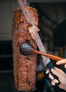 Chef cutting doner with knife in restaurant. Turkish Doner Kebab meat traditional fast food. Shish kebab doner grilled in fired ov Royalty Free Stock Photo