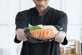 Chef cutting fish and making sashimi. Japan raw salmon slice or salmon sashimi in japanese style. Salmon sasimi on hand Royalty Free Stock Photo