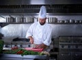 Chef cutting meat in restaurant kitchen Royalty Free Stock Photo