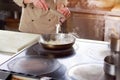 Chef cutting onion into frying pan. Royalty Free Stock Photo