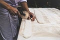 Chef cutting a pastry with pizza knife on table top in matte color. Royalty Free Stock Photo