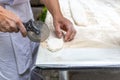 Chef cutting a pastry with pizza knife on table top in open kitchen. Royalty Free Stock Photo