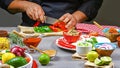 The chef cutting peppers into a plate. For cooking burritos. A delicious and spicy food concept, Mexican, cooking