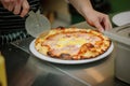 Chef cutting pizza with the round pizza cutter or knife. Royalty Free Stock Photo