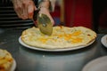 Chef cutting pizza with the round pizza cutter or knife. Royalty Free Stock Photo