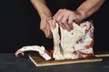 Chef cutting rack of lamb on wooden board in kitchen Royalty Free Stock Photo