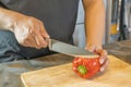 Chef cutting red bell pepper on wooden broad Royalty Free Stock Photo