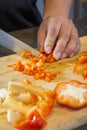 Chef cutting red bell pepper on wooden broad Royalty Free Stock Photo