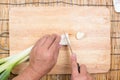 Chef cutting scallion on wooden broad Royalty Free Stock Photo