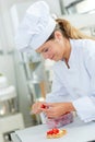 Chef cutting strawberries to decorate tart