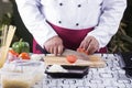 Chef cutting Tomato with knife befoer cooking Royalty Free Stock Photo