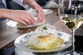 Chef decorates the halibut with mango sauce and rice noodles. Master class in the kitchen. The process of cooking. Step by step. Royalty Free Stock Photo