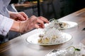 Chef decorates the halibut with mango sauce and rice noodles. Master class in the kitchen. The process of cooking. Step by step. Royalty Free Stock Photo