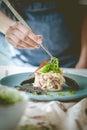 A chef is decorating a salad. Seaweed Salad