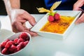 Chef decorating sweets at kitchen. Closeup male chef making dessert in motion. Professional cook decorating cake at workplace Royalty Free Stock Photo