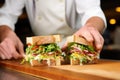 chef demonstrating sandwich layering techniques