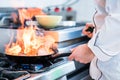 Chef doing flambe to dish in pan