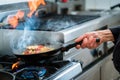 Chef doing flambe to food in pan with alcohol Royalty Free Stock Photo