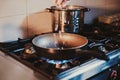 Chef dropping sliced onion in to a frying pan