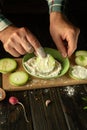 The chef dusts the sliced zucchini with flour before roasting. The concept of cooking vegetable marrow on the kitchen table with
