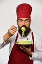 Chef eats italian or asian noodles. Man with beard