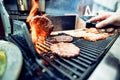 The chef flips the grilled hamburger cutlet. Royalty Free Stock Photo