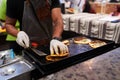 A chef folds over a taco at a busy food market Royalty Free Stock Photo