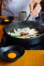 Chef fried onion, scallion and mushroom in Sukiyaki hot pot before adding Shoyu sauce soup for boiling Wagyu beef and Kurobuta. Royalty Free Stock Photo