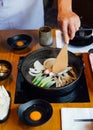 Chef fried onion, scallion and mushroom in Sukiyaki hot pot before adding Shoyu sauce soup for boiling Wagyu beef and Kurobuta. Royalty Free Stock Photo