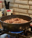 Chef fries meat rolls in a frying pan on a gas stove. French gourmet cuisine