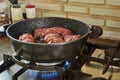 Chef fries meat rolls in a frying pan on a gas stove. French gourmet cuisine