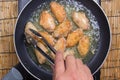 Chef frying chicken wings in pan