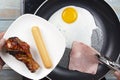 Chef frying egg ,ham,sausage and chicken drumstick in the pan