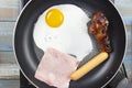 Chef frying egg ,ham,sausage and chicken drumstick in the pan Royalty Free Stock Photo