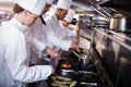 Chef frying fish in a frying pan