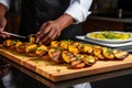 chef garnishing grilled plantains on a serving platter