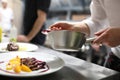 Chef garnishing in the kitchen garnishing their salads Royalty Free Stock Photo